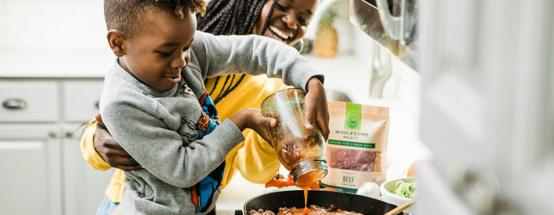 a mother and son making spaghetti