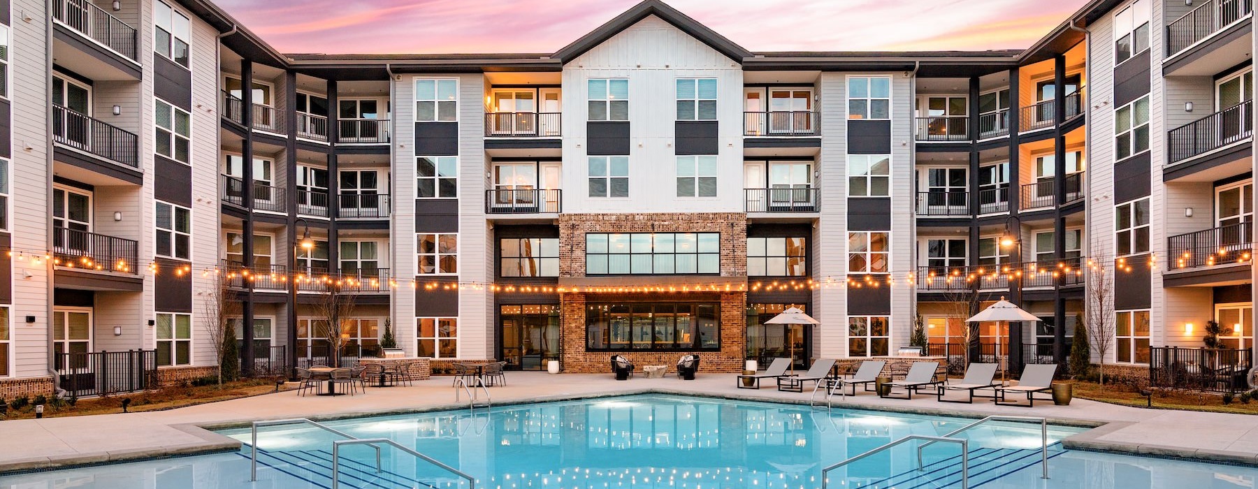a courtyard with a pool and chairs